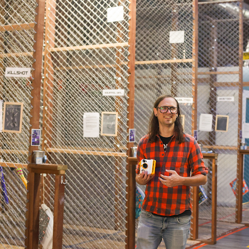 Eric with his retro Polaroid camera at the axe throwing cages