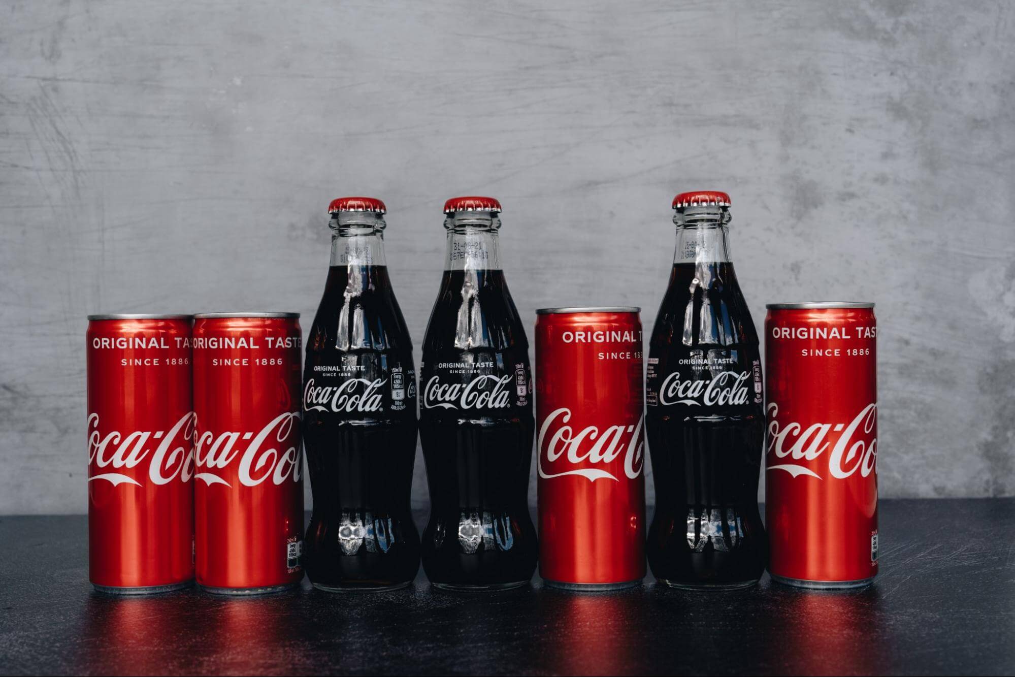 Coca-Cola brand attributes: bottles and cans showing the unique script font, the red cans, and the hourglass bottles.
