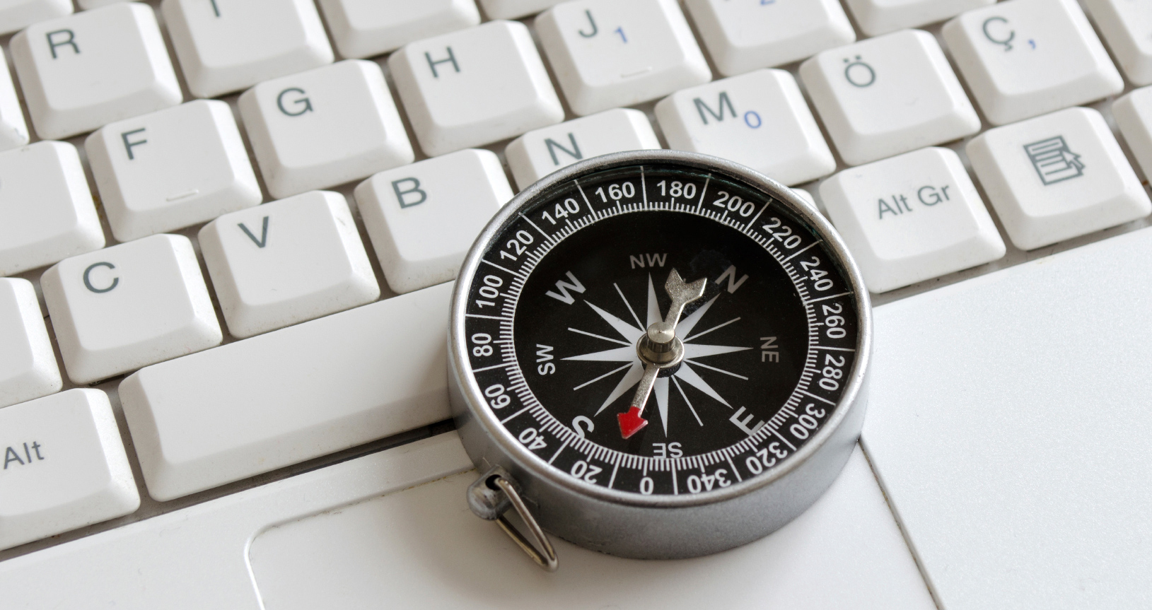 A compass on a keyboard demonstrating web navigation